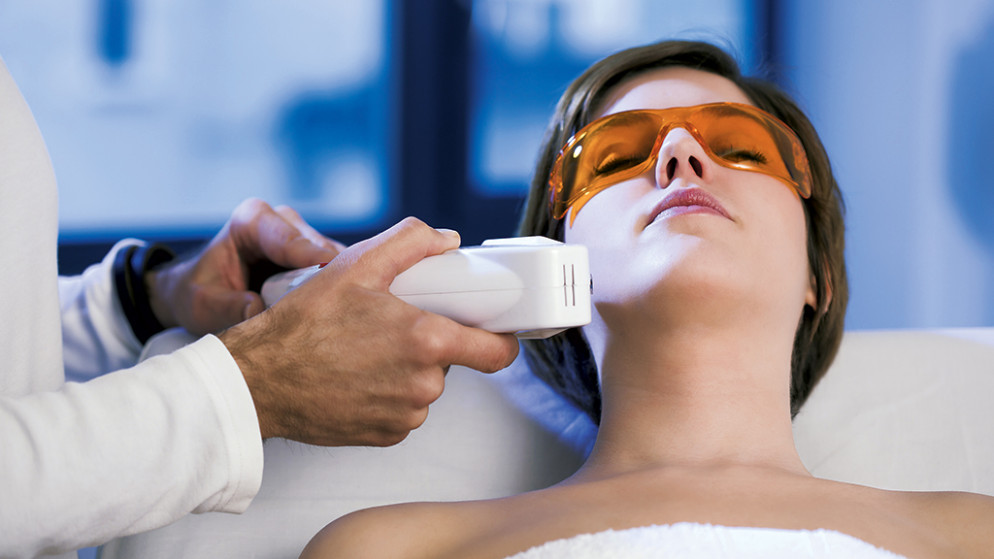 A qualified technician performing laser therapy for hair removal